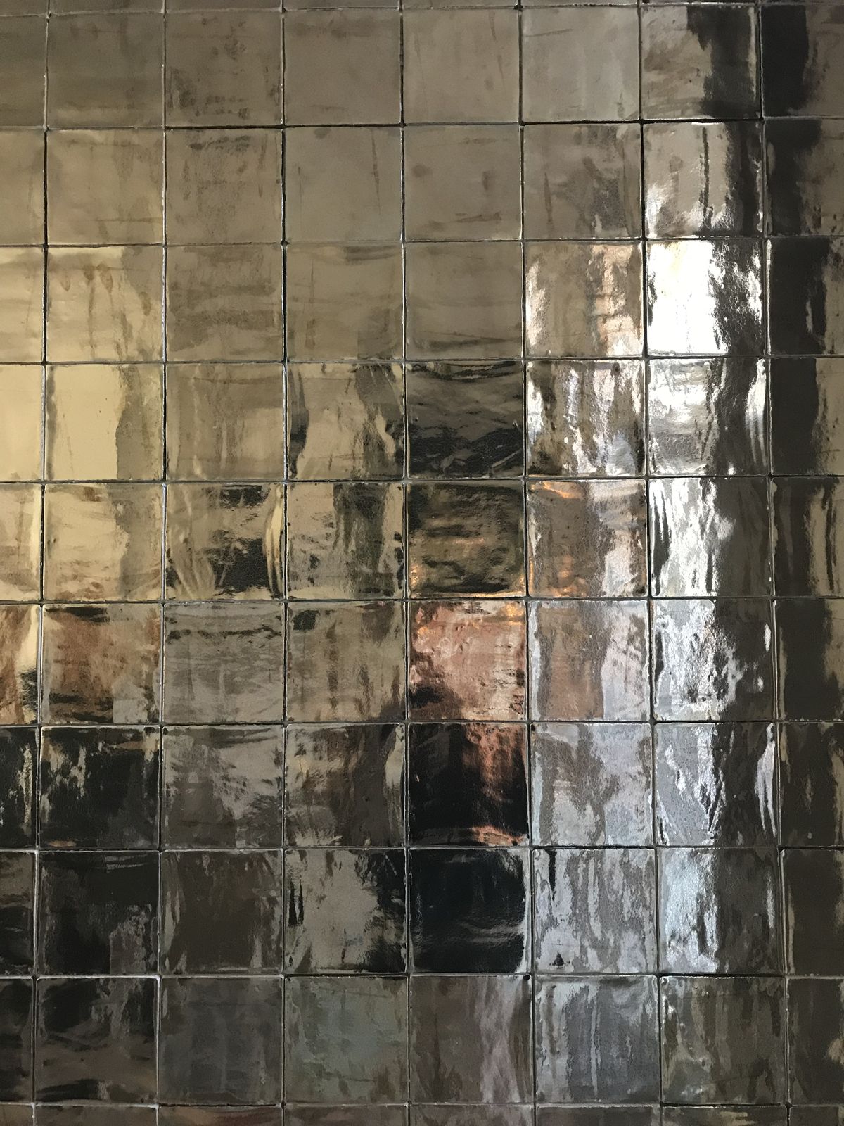 Azulejos metálicos espejados en plata y bronce con reflejos irregulares